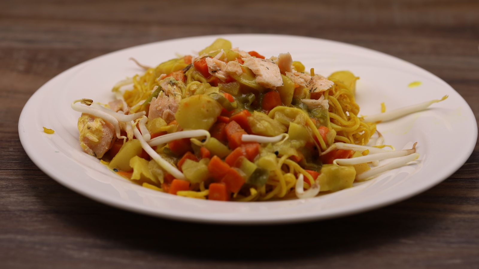 Pulled salmon on Asian noodles with coconut and vegetable sauce
